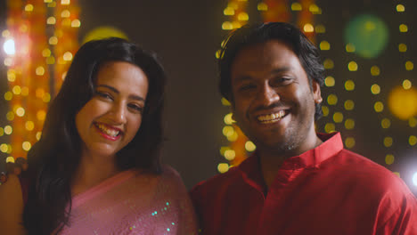 Porträt-Eines-Lächelnden-Asiatischen-Paares,-Das-Diwali-Vor-Bokeh-Beleuchtungshintergrund-Feiert